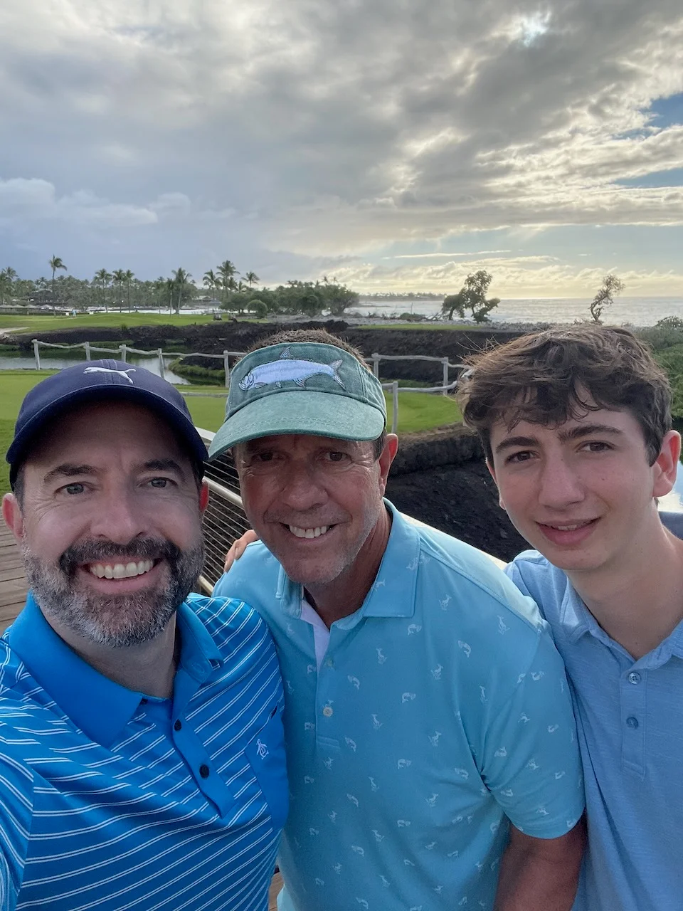 Three people smiling together on a golf course