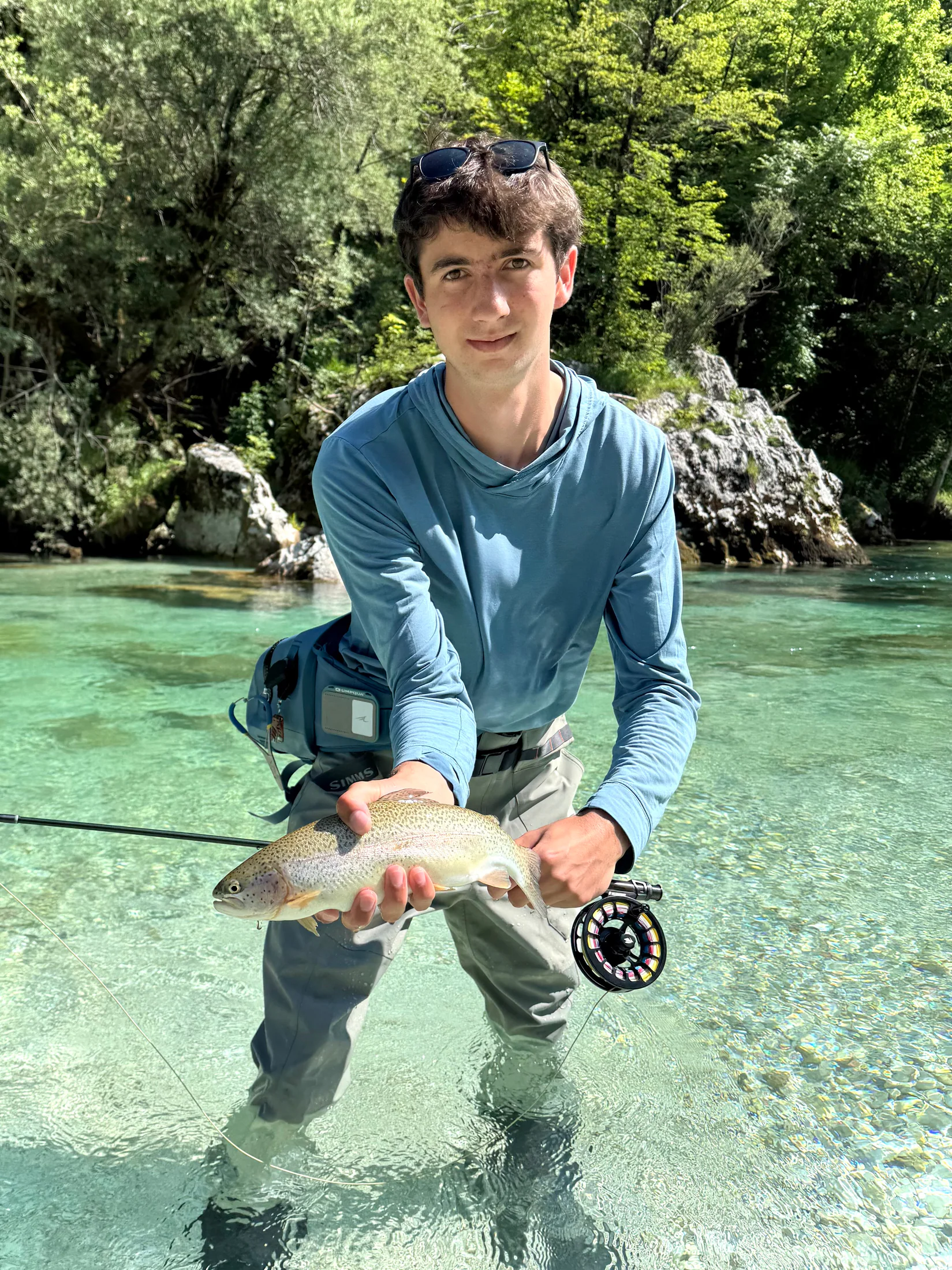 A trout held just above the water