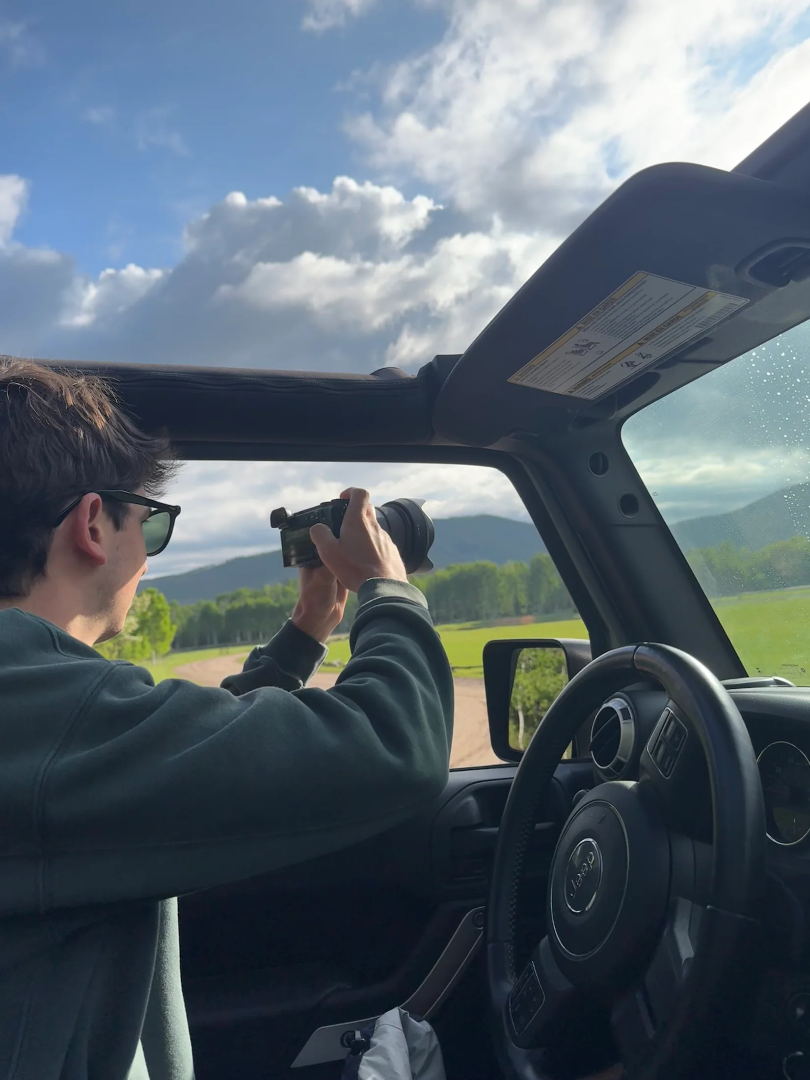 Judah photographing the Colorado landscape through the open roof of a Jeep