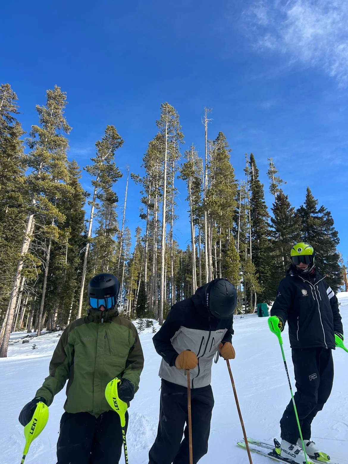 Judah skiing with friends among tall evergreens